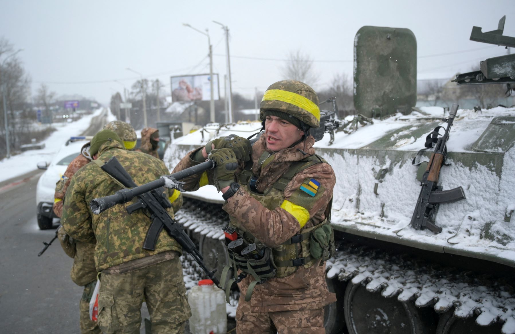 Ukrainian servicemen stand guard on a road in Kharkiv, Ukraine in front of a tank while holding weapons on February 25, 2022. REUTERS/Maksim Levin